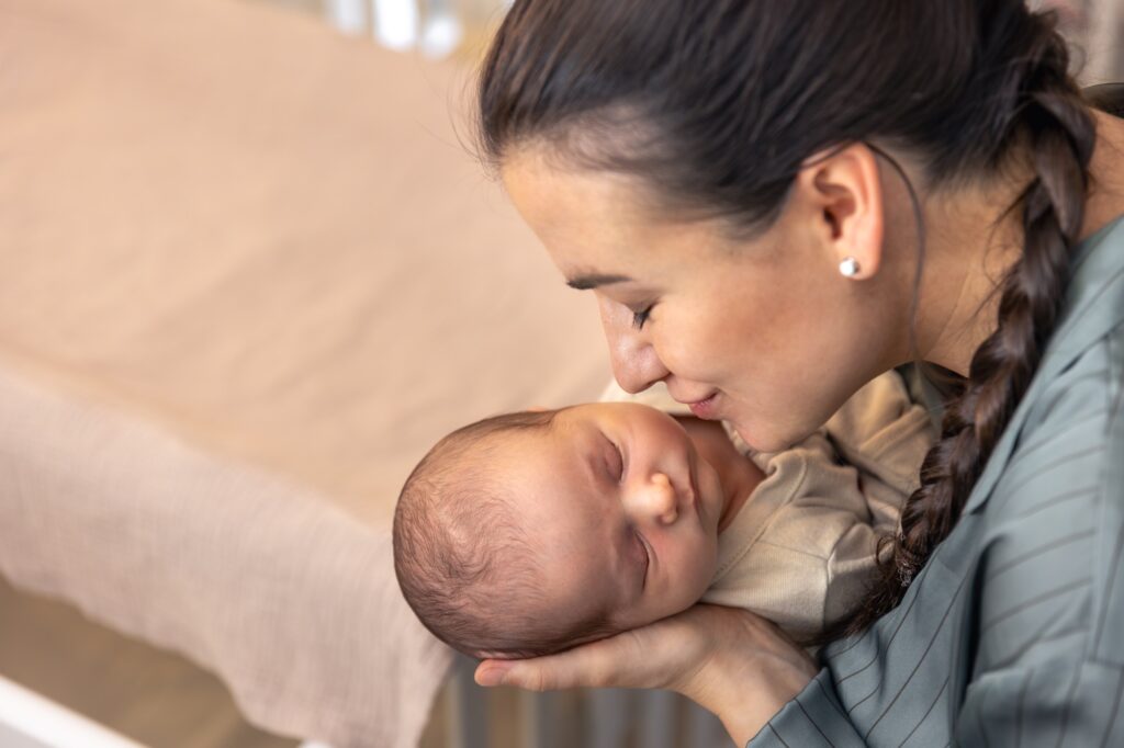 New mom kissing her new born with love and affection. Soaking in these new born smell. And enjoying her time with the baby 